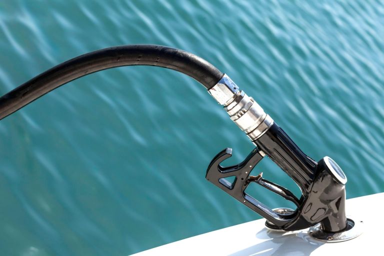 Closeup of Diesel pump nozzle refilling boat tank.